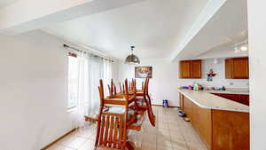 Dining area with light tile patterned floors and a textured ceiling