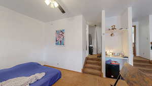 Carpeted bedroom featuring ceiling fan and baseboards