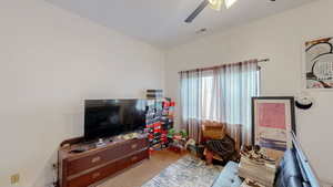 Living room featuring light colored carpet and ceiling fan