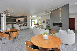Clubhouse- Dining area with a chandelier, recessed lighting, and a tile fireplace