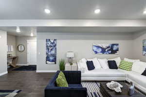 Living area featuring dark wood finished floors, a textured ceiling, and recessed lighting
