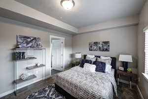 Bedroom with baseboards and dark colored carpet