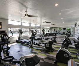 Exercise room featuring a textured ceiling, recessed lighting, and a ceiling fan