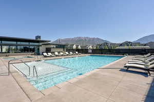 Community pool featuring a patio, a mountain view, and a residential view