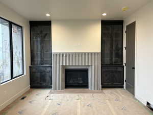 Unfurnished living room featuring a glass covered fireplace and recessed lighting