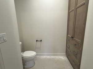 Bathroom with toilet and light marble finish floors