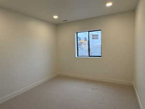 Carpeted empty room featuring baseboards and recessed lighting