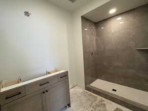 Bathroom with tiled shower and recessed lighting