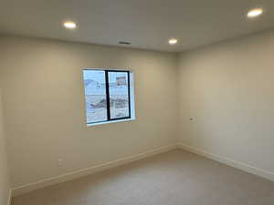Carpeted empty room featuring recessed lighting and baseboards