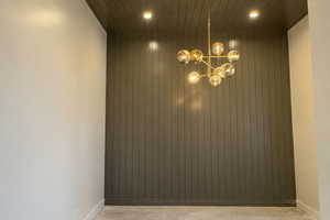 Spare room with suspended lighting and baseboards