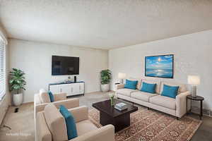 Carpeted living room featuring a textured ceiling and baseboards