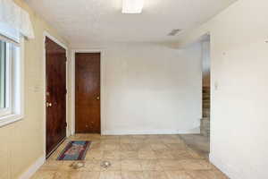 Hallway featuring wallpapered walls and a textured ceiling
