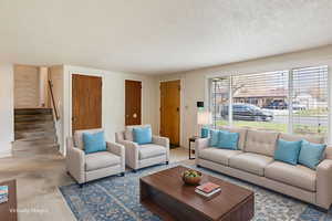 Living area featuring stairs and concrete floors