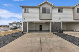 View of front of home featuring brick siding, concrete driveway, a residential view, and board and batten siding