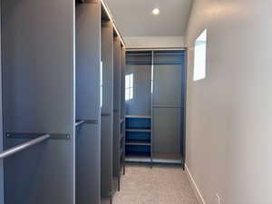 Spacious closet with light carpet