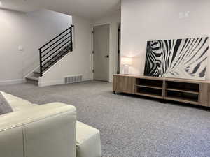 Living area with light carpet and stairway