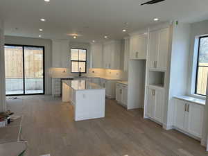 Kitchen with a center island, plenty of natural light, white cabinetry, and recessed lighting