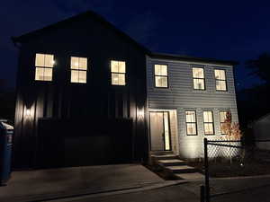 View of front facade featuring board and batten siding, a garage, and concrete driveway