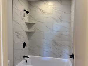 Ensuite Bathroom featuring bathtub / shower combination and toilet