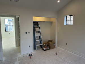 Unfurnished bedroom featuring baseboards and lofted ceiling