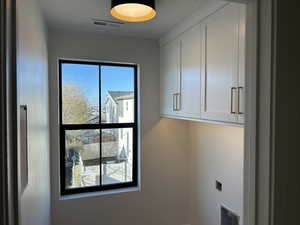Washroom with cabinet space and hookup for an electric dryer