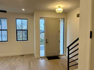 Entryway with light wood finished floors, plenty of natural light, and recessed lighting