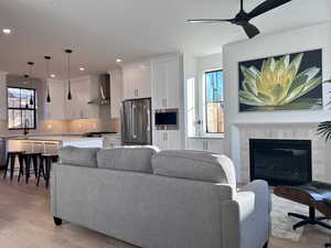 Living area featuring light wood finished floors, recessed lighting, healthy amount of natural light, and a ceiling fan