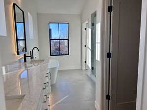 Primary Ensuite bathroom with double vanity, a shower stall, a freestanding bath, and vaulted ceiling
