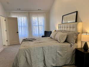 Carpeted bedroom with lofted ceiling