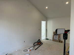Empty room with baseboards and lofted ceiling