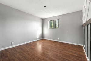 Spare room with dark wood finished floors and baseboards