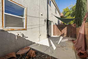View of side of property featuring stucco siding and a patio area