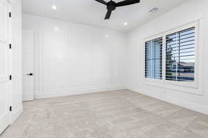 Spare room featuring light colored carpet, ceiling fan, a decorative wall, and recessed lighting