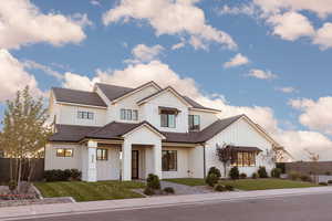 Modern farmhouse featuring board and batten siding and a tile roof