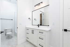 Bathroom featuring vanity and light marble finish flooring