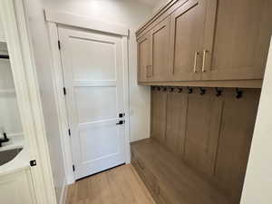 Mudroom featuring light wood-style flooring and a sink