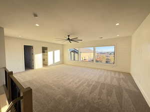 Unfurnished room featuring recessed lighting, light colored carpet, ceiling fan, and wood walls