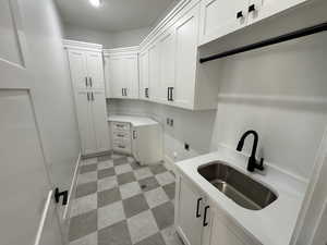 Laundry room with cabinet space, light floors, hookup for a washing machine, and electric dryer hookup