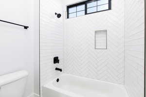 Bathroom featuring bathing tub / shower combination and toilet