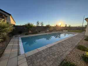 View of swimming pool featuring a fenced backyard and a patio