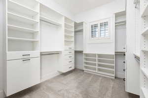 Spacious closet with light colored carpet