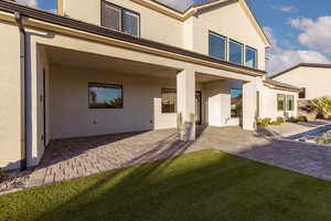 Back of property featuring a patio area, stucco siding, a yard, and an outdoor pool