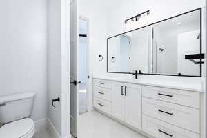 Bathroom featuring vanity, light tile patterned floors, and a tile shower