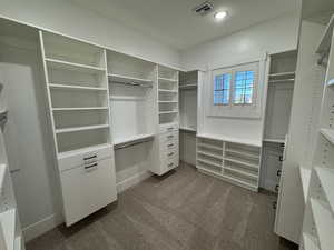 Walk in closet featuring dark carpet