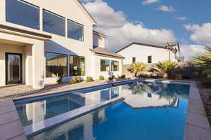 View of swimming pool with a patio and a pool with connected hot tub