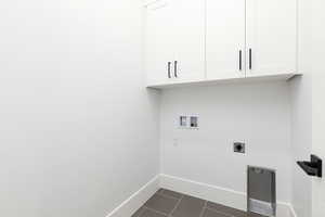 Laundry area with washer hookup, dark tile patterned floors, electric dryer hookup, and cabinet space