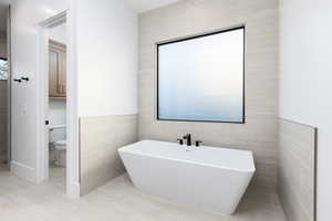 Full bathroom with a freestanding tub and tile walls