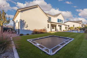 Rear view of property with a patio, stucco siding, and a lawn