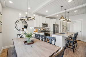 Dining area featuring light wood-style floors, recessed lighting, a chandelier, and a wooden ceiling with exposed beams