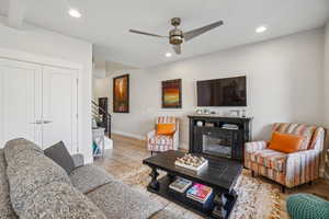 Living room with wood finished floors, recessed lighting, and a ceiling fan